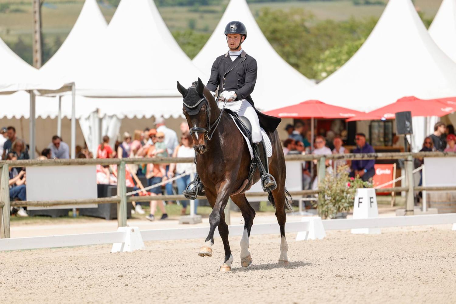 Tristan Le Minoux en reprise de dressage, public en arrière-plan